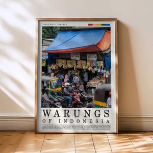 May include: A framed print titled "Warungs of Indonesia" depicting a busy street scene in Jakarta. The image shows a market with vendors, motorcycles, and a blue and orange awning. The text "Issue No. 8: Jakarta" is at the top.