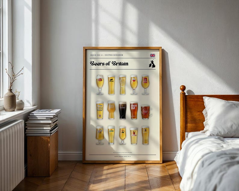 May include: A framed poster titled "Beers of Britain" featuring illustrations of various beer glasses. The poster includes the Union Jack flag and a map of the UK. The poster is displayed in a room with a wooden bed frame and a stack of books.