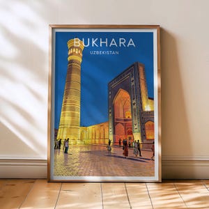 May include: Framed art print featuring a nighttime view of Bukhara, Uzbekistan. The image showcases a tall, illuminated minaret and a detailed mosque with arched entrances. The word "BUKHARA" is printed at the top.