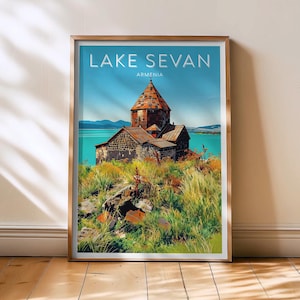 May include: A framed print of Lake Sevan in Armenia. The artwork features a stone church with a red-tiled roof on a grassy hill, set against a turquoise lake and blue sky. The words "LAKE SEVAN ARMENIA" are printed at the top.