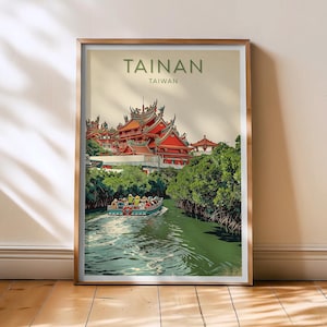 May include: A framed travel poster for Tainan, Taiwan. The image depicts a red-roofed temple complex with a boat on a green waterway. The poster has the word "TAINAN" in green letters at the top, with "TAIWAN" below it.