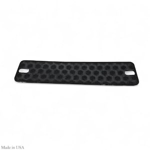 May include: Black rectangular object with a honeycomb pattern and two oval holes. The object is made in the USA.