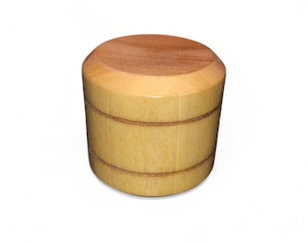 May include: A cylindrical wooden object with a light brown body and a darker brown top. The body has two horizontal grooves. The text "Made in USA" is at the bottom.