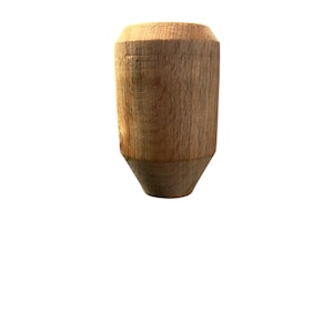 May include: A wooden bottle stopper with a light brown, natural wood grain finish. The stopper has a cylindrical body with a tapered bottom. The top is a wider, flat surface. The wood grain is visible on the surface.