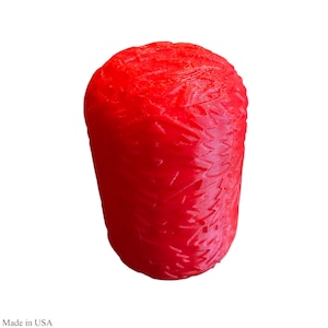 May include: A bright red, cylindrical object with a textured surface. The object has a rounded top and appears to be made of a solid material. The item is set against a plain white background.