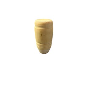 Puede incluir: Una pata de mueble de madera clara sin terminar. La pata tiene forma de barril con una parte superior redondeada y una parte inferior cónica. La veta de la madera es visible y la pata es lisa.