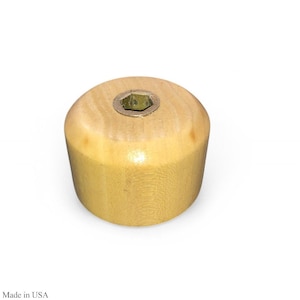 Puede incluir: Una pata de mueble de madera clara con forma cilíndrica. La parte superior presenta una inserción metálica con forma hexagonal. La pata está fabricada en EE. UU.