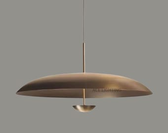 Puede incluir: Una lámpara colgante moderna de color bronce. La lámpara tiene una pantalla grande, plana, en forma de disco y un elemento más pequeño en forma de cuenco suspendido debajo. El texto "ACE LIGHTING" es visible.