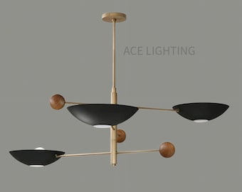 Puede incluir: Lámpara colgante moderna en negro y dorado con tres luces orientadas hacia abajo y detalles de madera. La lámpara de techo tiene el texto "ACE LIGHTING".