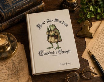 Puede incluir: Un libro de tapa dura con cubierta color crema que presenta una ilustración de una rana verde con túnica y capa. El texto dice: Hark! Mine Mind Hath Conceived a Thought. El nombre del autor Dylan Jones está impreso en la parte inferior.