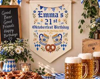 Puede incluir: Un estandarte de tela color crema con patrones de rombos azules y blancos, dos jarras de cerveza chocando y un pretzel. El texto dice: Emma's 21st Oktoberfest Birthday, Prost to the Birthday Girl! El diseño incluye detalles florales.