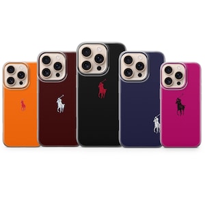 Puede incluir: Cinco fundas de teléfono de colores en naranja, burdeos, negro, azul marino y magenta. Cada funda presenta un borde transparente y un logotipo de una persona a caballo. Las fundas están diseñadas para un smartphone.