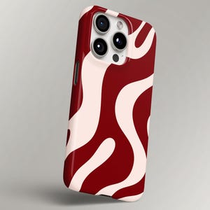 May include: A smartphone case with a maroon background and a flowing, abstract pattern in a lighter shade of pink. The case has a glossy finish and features a camera module with three lenses.