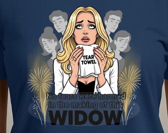 May include: Navy blue t-shirt featuring a cartoon illustration of a blonde woman holding a "Tear Towel". The image includes the text "No tears were harmed in the making of this WIDOW". The design has a comedic theme.
