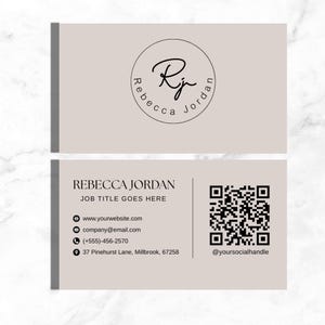 May include: Beige business card with the name "Rebecca Jordan" and a logo featuring the initials "Rj" in a circular design. The card includes contact information: website, email, phone number, and address, along with a QR code and social media handle.