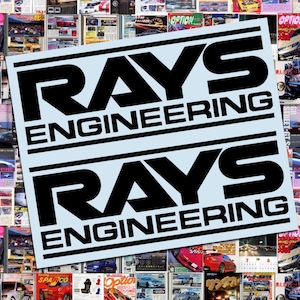 May include: A collage of car magazines with a light blue sticker featuring the text "RAYS ENGINEERING" in bold black letters. The magazines showcase various car models and automotive content.
