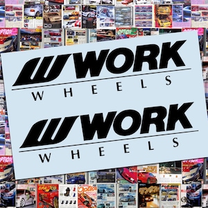 May include: A light blue background features the black logo of "WORK WHEELS" in a bold, stylized font. The background is a collage of colorful car magazine covers, creating a dynamic and automotive-themed composition.