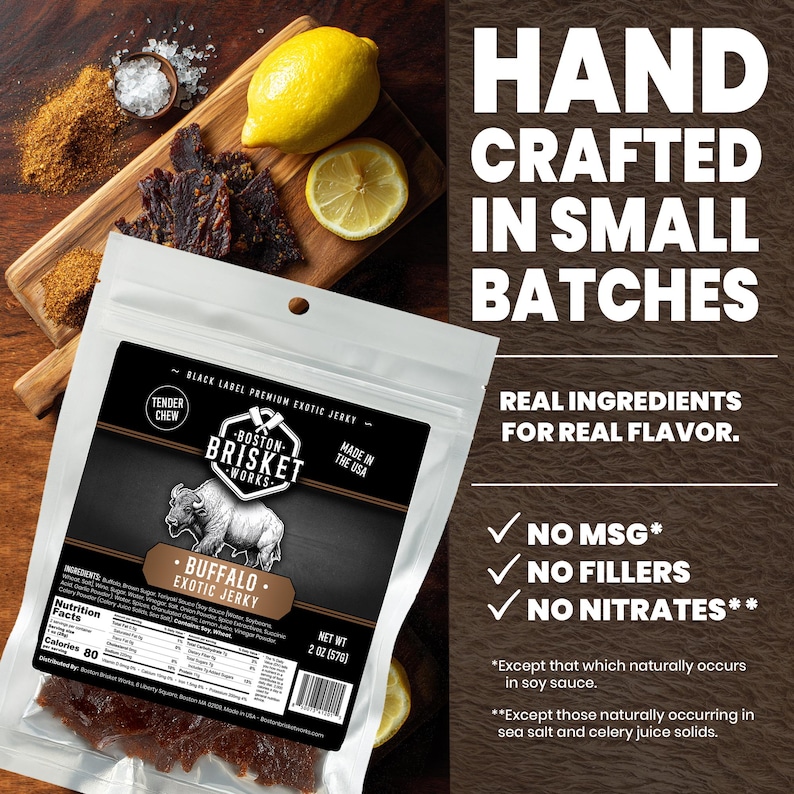 K&ouml;nnte beinhalten: Eine Packung Boston Brisket Works Buffalo Exotic Jerky mit einer B&uuml;ffel-Illustration vor einem Holzbrett mit Jerky, Zitronenscheiben und Gew&uuml;rzen. Die Packung weist "Hand Crafted in Small Batches" und "No MSG, Fillers, or Nitrates" auf.