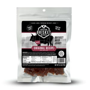 Op de afbeelding: Een doorzichtige plastic verpakking van Boston Brisket Works Original Recipe Brisket Beef Jerky. De verpakking heeft een zwart etiket met het merklogo, een diagram van een koe en de tekst "Made in the USA". Nettogewicht: 71g.