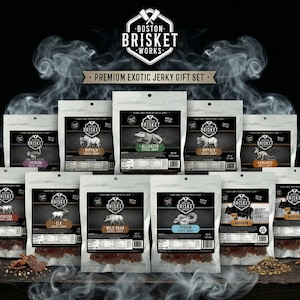 Op de afbeelding: Een premium exotische jerky cadeau set met diverse smaken, waaronder alligator, buffel en wild zwijn. De witte verpakkingen hebben zwarte labels met illustraties van het vlees. De merknaam "Boston Brisket Works" staat bovenaan.
