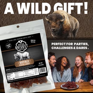 K&ouml;nnte beinhalten: Eine transparente T&uuml;te mit Boston Brisket Works Buffalo Exotic Jerky mit einer B&uuml;ffel-Illustration. Die T&uuml;te ist mit "A WILD GIFT!" und "PERFECT FOR PARTIES, CHALLENGES & DARES." beschriftet. Das Nettogewicht betr&auml;gt 57 Gramm.