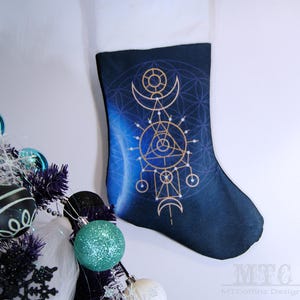 May include: A blue and gold Christmas stocking with a geometric design. The stocking features a circle, triangle, and crescent moon pattern.