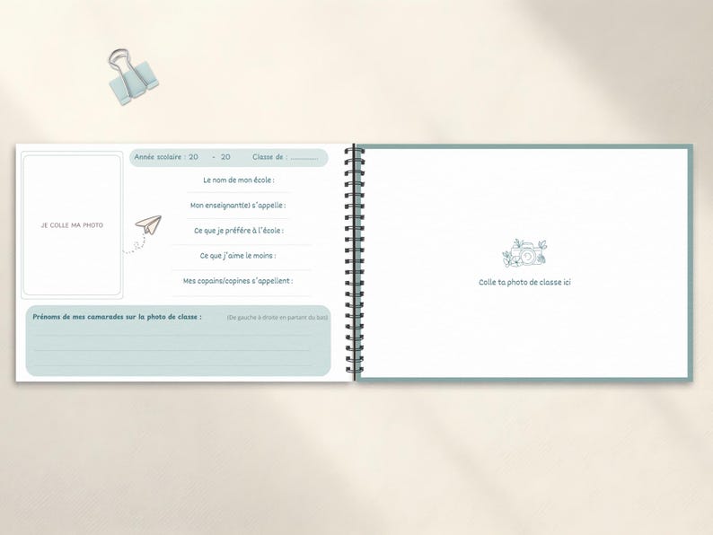 May include: A spiral-bound school memory book with light blue accents. The left page has space for a photo and prompts to fill in details like school name and favorite things. The right page has space for a class photo.