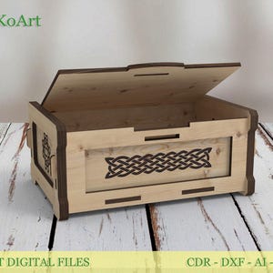 Pode incluir: Uma caixa de madeira com tampa articulada, com um desenho de nó celta no painel frontal. A caixa é feita de madeira clara com acabamentos castanhos escuros. O texto "EsTetiKoArt" está no canto superior esquerdo e "LASER CUT DIGITAL FILES" na parte inferior.