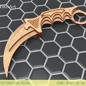 Op de afbeelding: Een houten karambitmes met een gebogen lemmet en vingerring. Het mes is gemaakt van gelaagd hout, met een lichtbruine kleur. De handgreep heeft een gedetailleerd ontwerp. De tekst "Laser Cut Digital Files" is zichtbaar onderaan.