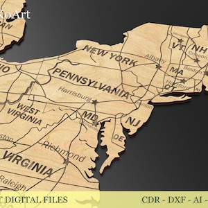 May include: A laser-cut wooden map of the United States, featuring state outlines, major cities, and roads. The map is light brown with dark brown engraved details. Text at the bottom reads "LASER CUT DIGITAL FILES".