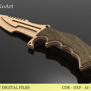May include: A wooden knife with a light brown blade and a dark brown handle. The knife has a serrated edge and a detailed design. The image includes the text "EsTetiKoArt" and "LASER CUT DIGITAL FILES".