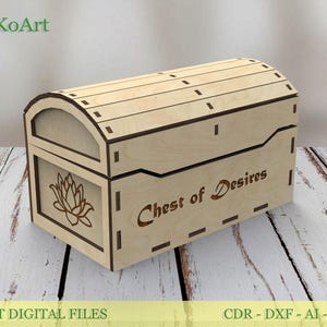 Op de afbeelding: Een lichtgekleurde houten kist met een gebogen deksel en de woorden "Chest of Desires" gegraveerd op de voorkant. De kist heeft een lotusbloemontwerp en is gemaakt van lasergesneden digitale bestanden.