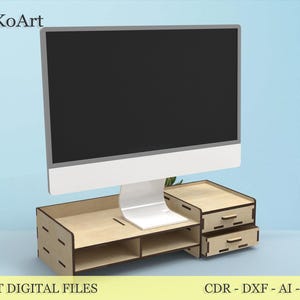 Puede incluir: Un soporte de monitor de ordenador de madera con dos cajones y estantes abiertos. El soporte es de madera de color claro y tiene un diseño moderno. El monitor es una pantalla plana grande con una base blanca. El texto "LASER CUT DIGITAL FILES" está en la parte inferior.