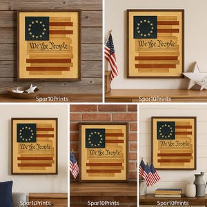 May include: Framed artwork featuring a stylized American flag design. The flag includes a blue canton with 13 stars, and the words "We the People" are displayed. The artwork is in a brown frame.