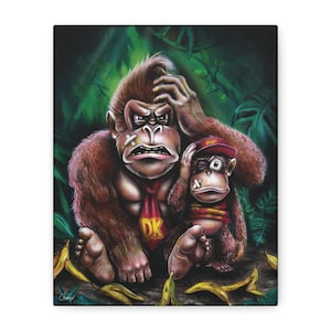 May include: A canvas print featuring a large brown gorilla wearing a red tie with the yellow letters DK, sitting next to a smaller monkey in a red cap. Both figures have white bandages on their faces, set against a dark green jungle background.