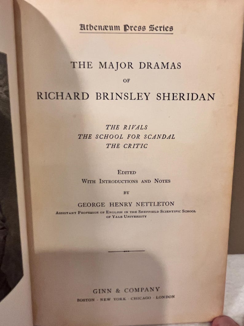 May include: Open book titled "THE MAJOR DRAMAS OF RICHARD BRINSLEY SHERIDAN" from the Athen&aelig;um Press Series. The book lists "THE RIVALS", "THE SCHOOL FOR SCANDAL", and "THE CRITIC". Edited by George Henry Nettleton, published by Ginn & Company.