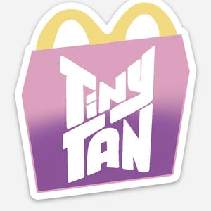 May include: A sticker featuring a stylized design resembling a fast-food container. The container is a gradient of pink and purple, with the words "TINY TAN" in bold white letters. The top has yellow arches.