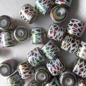 May include: A collection of iridescent white ceramic beads with a decorative white pattern. The beads have a rainbow sheen and are perfect for jewelry making.