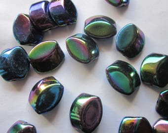 May include: A collection of iridescent glass beads in shades of green, blue, and purple. The beads are oval shaped and have a smooth, glossy finish.