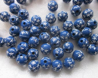 May include: A collection of blue plastic beads with a white star design. The beads are round and have a hole in the center for stringing.