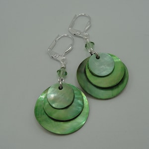May include: Green layered shell earrings with silver leverback closures and a crystal bead accent.