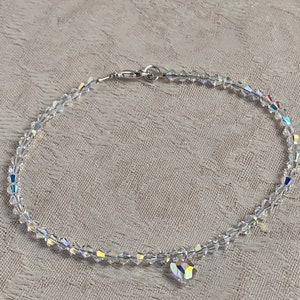 Pu&ograve; includere: Una delicata cavigliera di cristallo trasparente con un ciondolo a forma di cuore. La cavigliera &egrave; composta da piccoli cristalli sfaccettati collegati da una chiusura color argento. Il ciondolo a forma di cuore &egrave; anch'esso realizzato in cristallo trasparente.