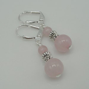 May include: A pair of silver earrings with pink rose quartz beads and silver floral accents.