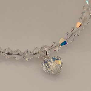 Pu&ograve; includere: Un braccialetto di cristallo trasparente con un ciondolo a forma di cuore. Il braccialetto &egrave; composto da piccoli cristalli sfaccettati infilati insieme. Il ciondolo a forma di cuore &egrave; anch'esso in cristallo e riflette la luce, creando un effetto scintillante.