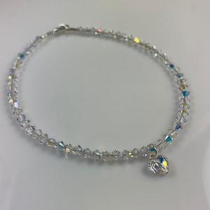 Pu&ograve; includere: Una cavigliera di perline di cristallo trasparente con un piccolo ciondolo a forma di cuore. La cavigliera &egrave; composta da piccoli cristalli sfaccettati infilati su un filo sottile. Il ciondolo a forma di cuore &egrave; anch'esso realizzato in cristallo trasparente.