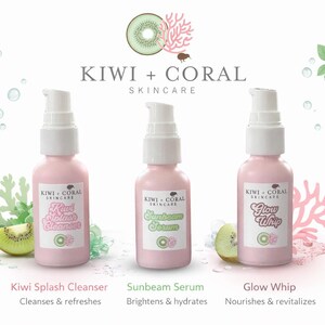Two pink pump bottles of Kiwi + Coral Skincare on a white background: Kiwi Splash Cleanser and Glow Whip, displayed beneath the brand logo with kiwi slices, coral accents, and water droplets.