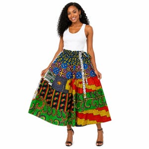 May include: A white sleeveless tank top paired with a long, flared skirt featuring a vibrant patchwork of multi-colored patterns. The skirt displays sections of green, red, yellow, and blue geometric and organic prints with a tie-waist detail.