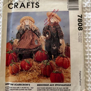 May include: A McCall's Crafts sewing pattern envelope 7808 featuring two scarecrow dolls and several fabric pumpkins. The text includes 'McCall's Crafts', '7808', and 'Meet the scarecrow's scarecrow dolls are 21 inches tall'.