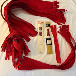 Puede incluir: Una colección de cremalleras rojas Talon de varias longitudes, algunas enrolladas y otras rectas. También hay dos paquetes de cremalleras Talon, con texto que indica "Lifetime Guarantee" y "Self-Locking Slide".