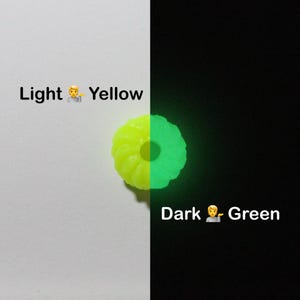 K&ouml;nnte beinhalten: Ein geteiltes Bild zeigt ein gelbes, ringf&ouml;rmiges Objekt, das auf der rechten Seite gr&uuml;n leuchtet. Die linke Seite ist wei&szlig; mit dem Text "Light Yellow". Die rechte Seite ist schwarz mit dem Text "Dark Green".